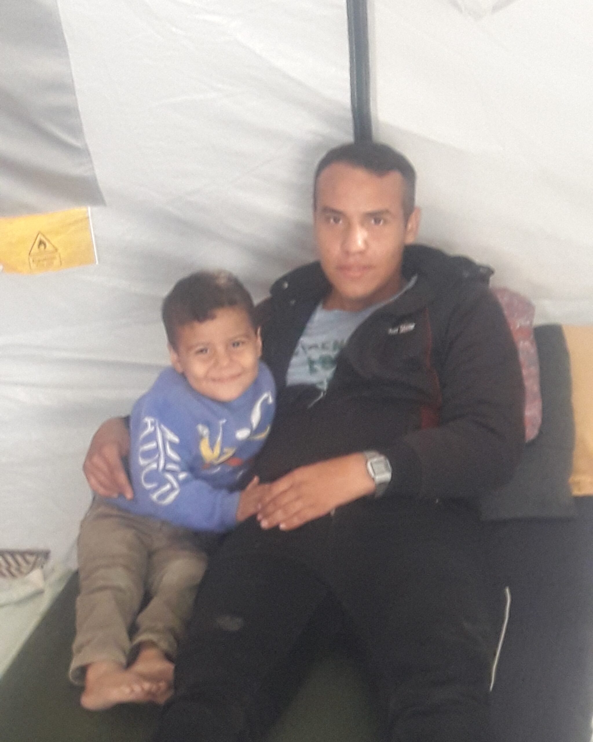 Photo courtesy of Amer’s family. Amer and his father Raafat seated inside a tent, showing family members relying on temporary shelter; image for Gaza family emergency aid.