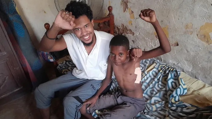 Medical Aid for Sudan Campaign Mohanned and a boy in Sudan raising fists after receiving medical aid.