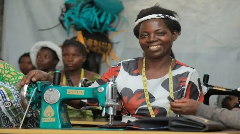 Woman in Congo smiling while learning sewing skills.