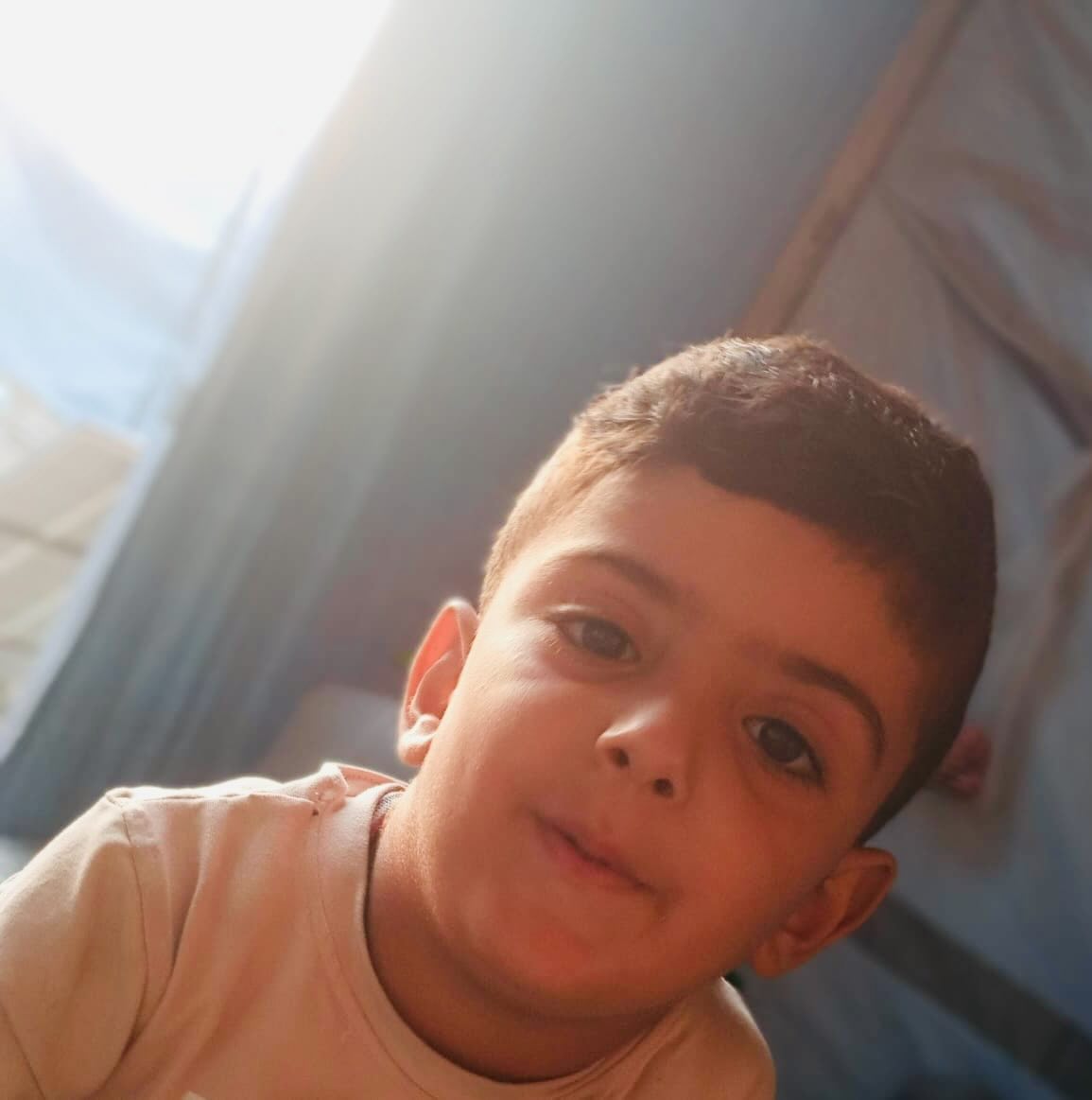 Yamen smiling in displacement shelter; Gaza child medical aid.