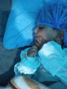 Child in hospital bed after surgery; Gaza child medical aid.